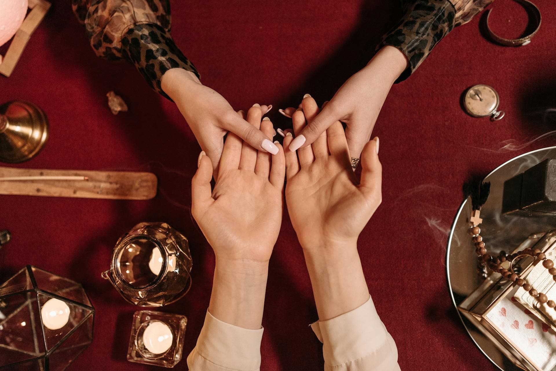 Two people with hands palm up over tarot cards