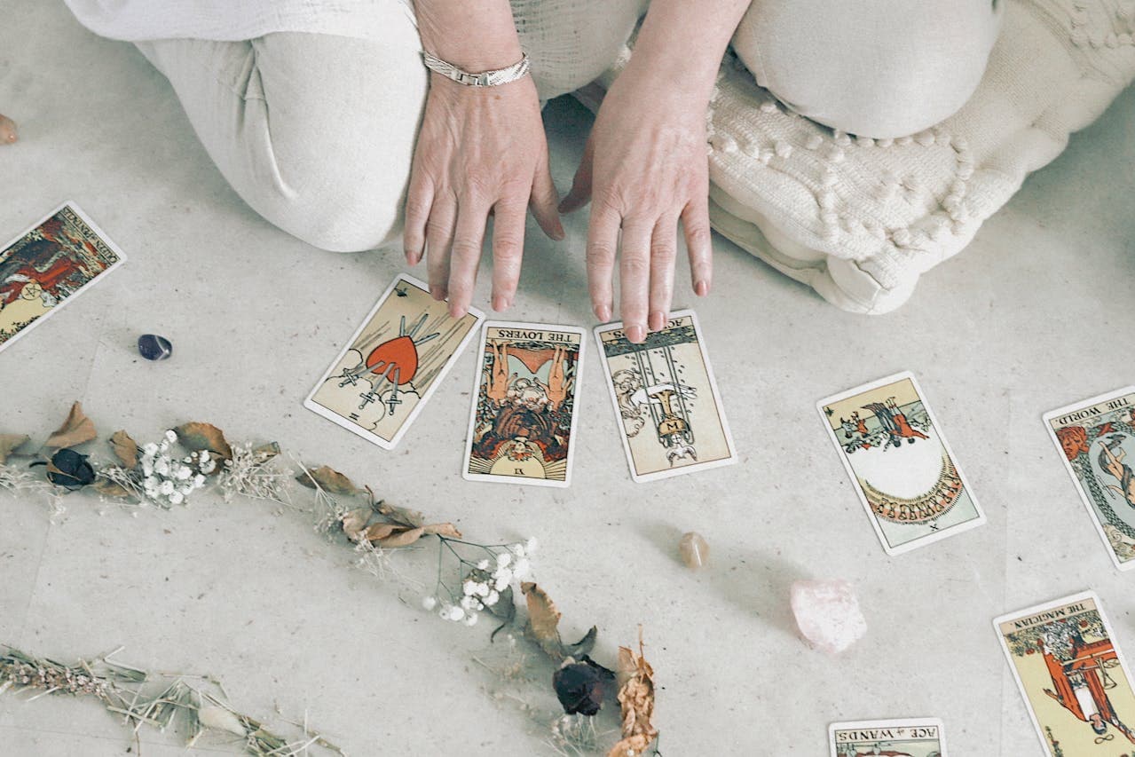 An array of oracle and tarot cards surrounded by crystals and light.
